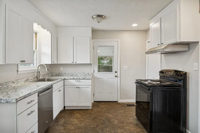 a kitchen with a stove sink and cabinets