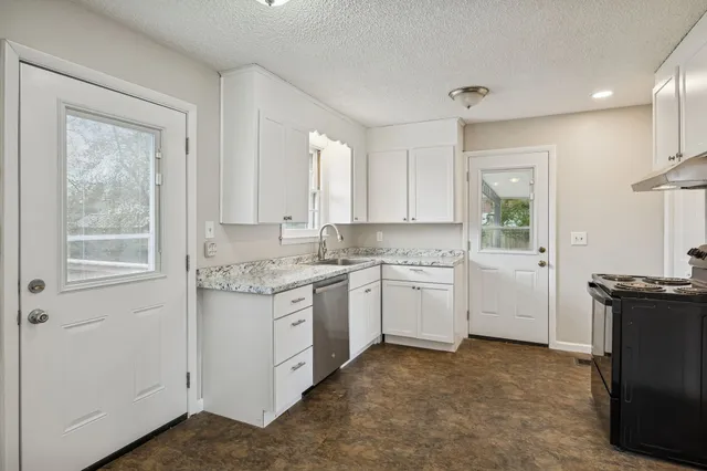 a kitchen with a stove top oven sink and window