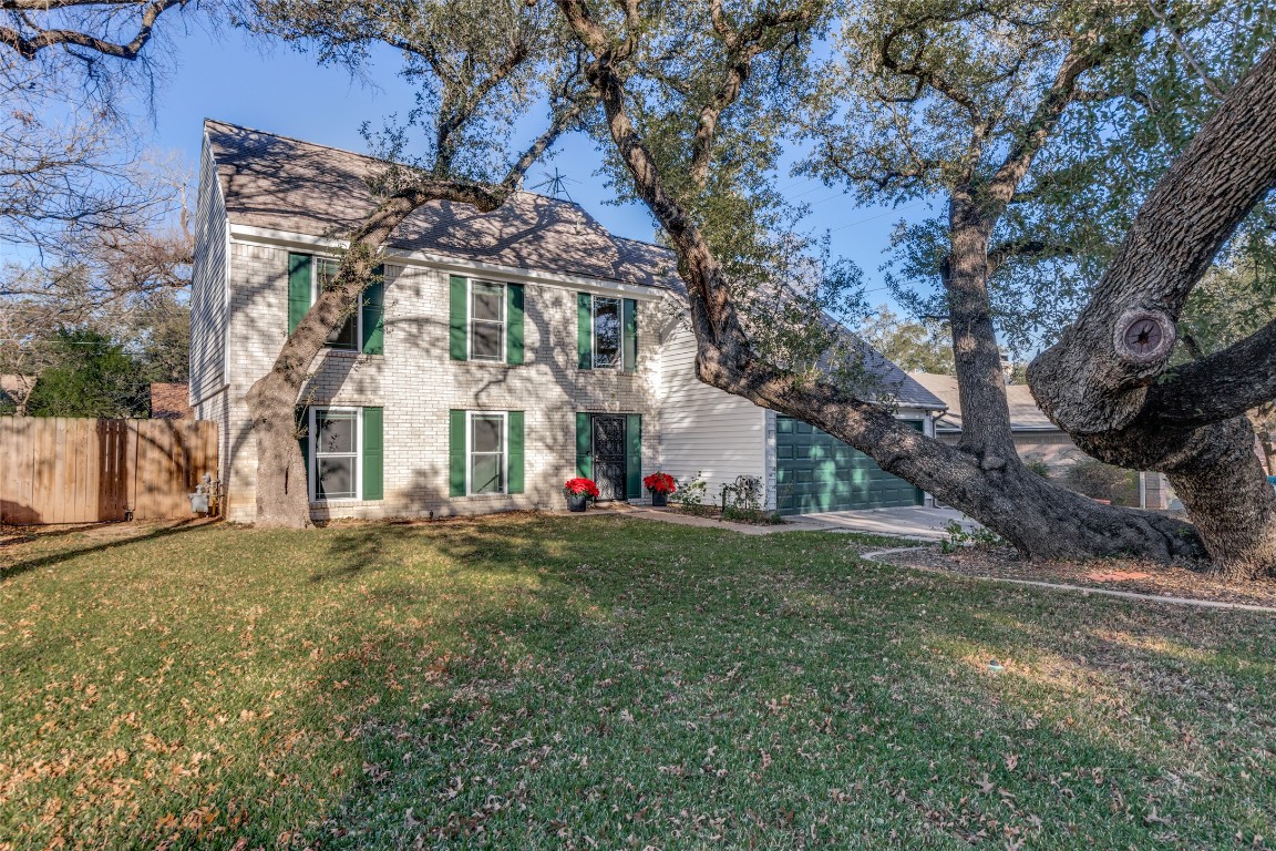 a view of a white house with a yard and large tree