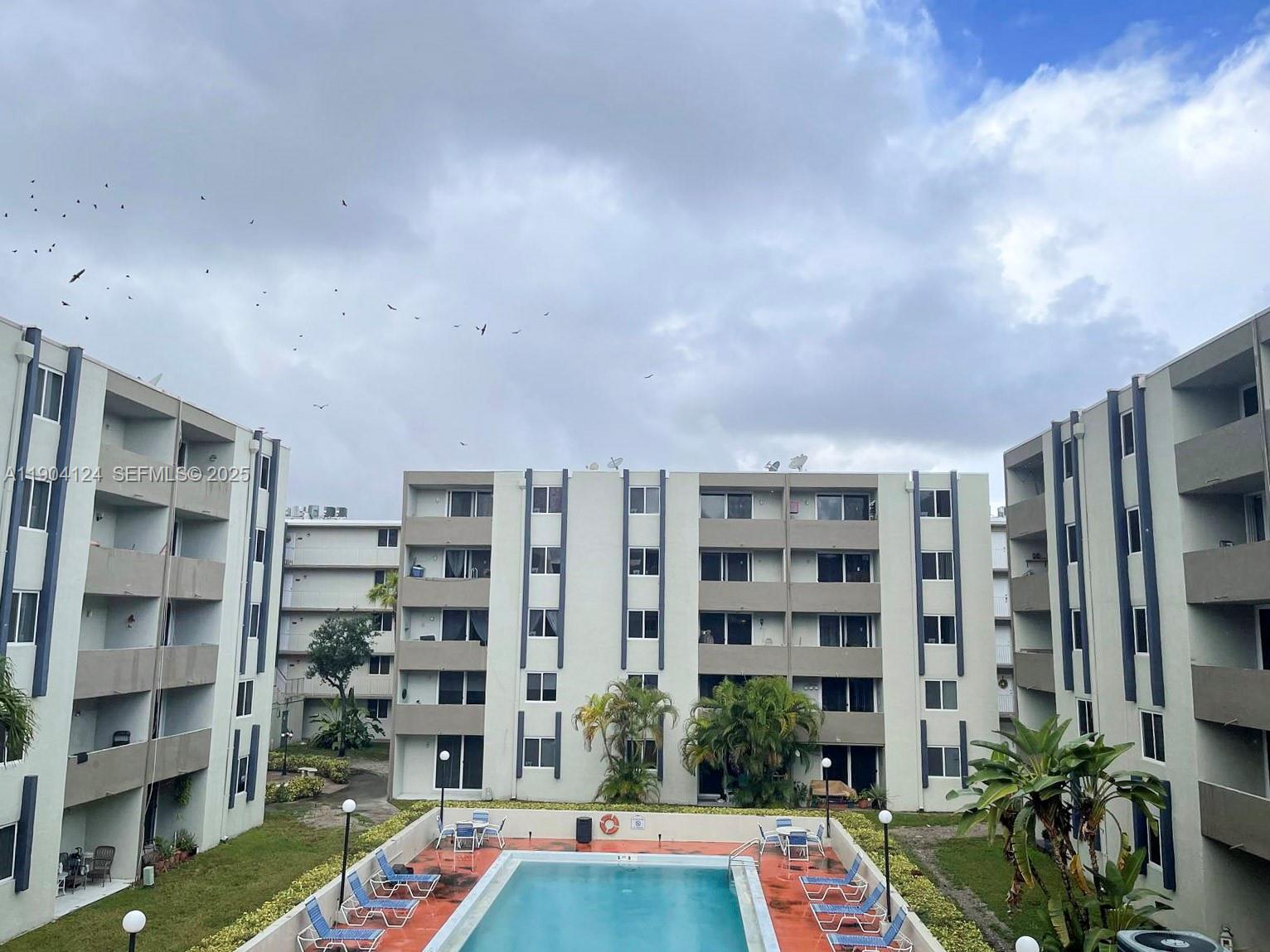 10090 Northwest 80th Court, Unit 1340 Hialeah Gardens, FL 33016 - Photo 1 of 17 a workspace with a book shelf