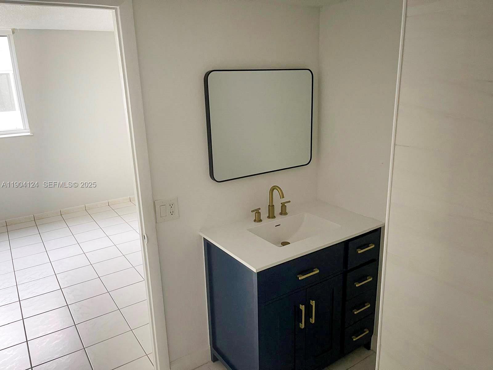 10090 Northwest 80th Court, Unit 1340 Hialeah Gardens, FL 33016 - Photo 15 of 17 a bathroom with a sink vanity and a mirror