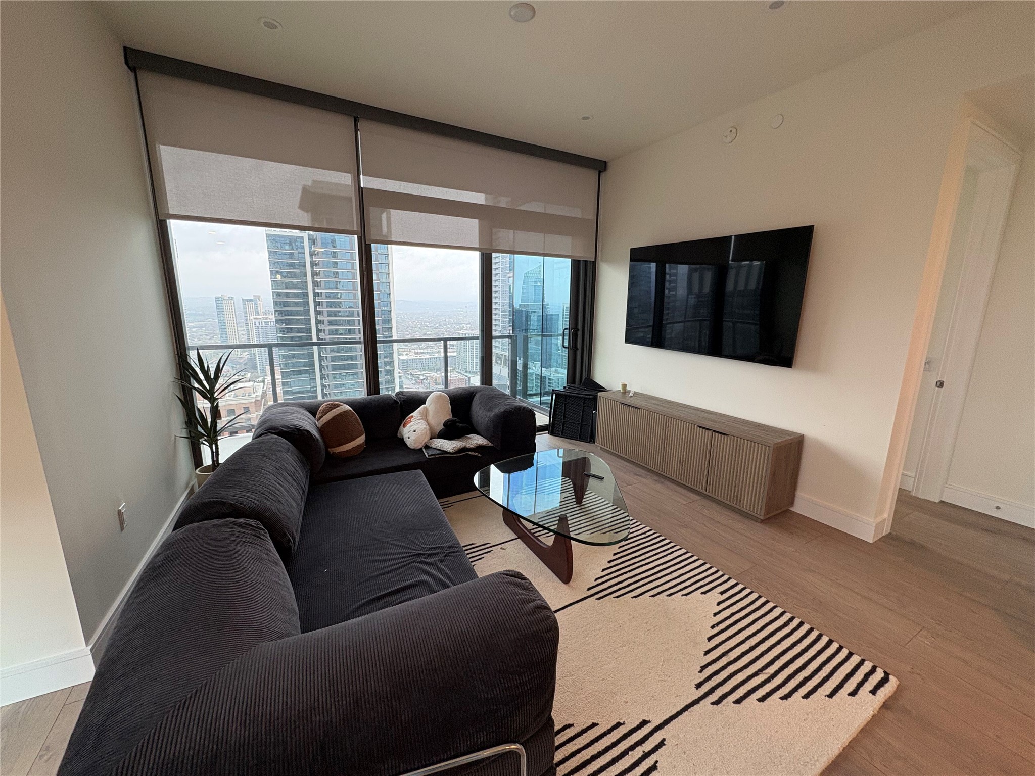 a living room with furniture a flat screen tv and a large window