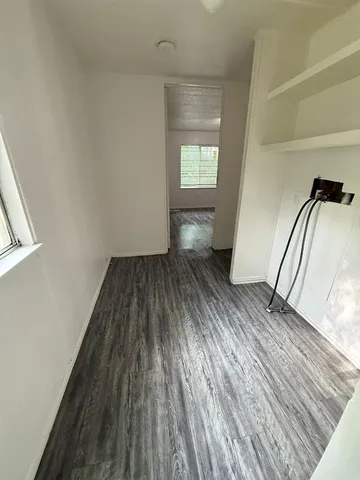 a view of a hallway with wooden floor