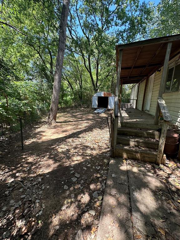109 East Prospect Street Denison, TX 75021 - Photo 4 of 16 a view of backyard with a table and chairs under an umbrella