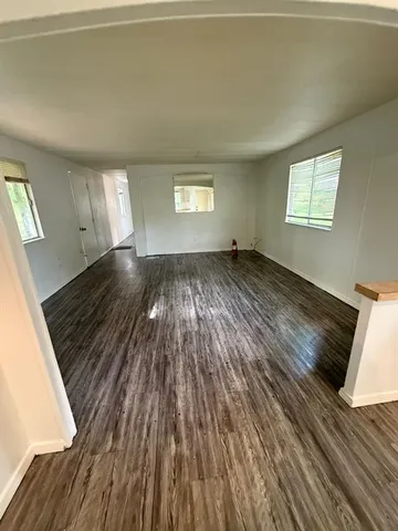 a view of a room with wooden floor and a window