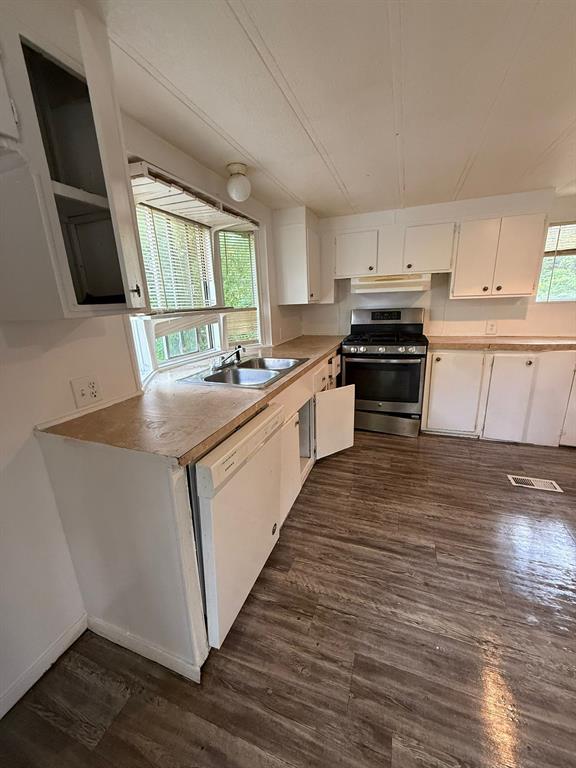 109 East Prospect Street Denison, TX 75021 - Photo 10 of 16 a kitchen with a sink a stove a microwave and wooden floor