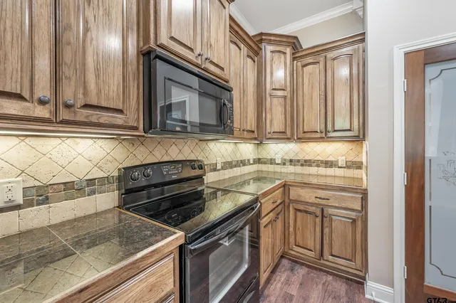 a kitchen with granite countertop stainless steel appliances a stove microwave and sink