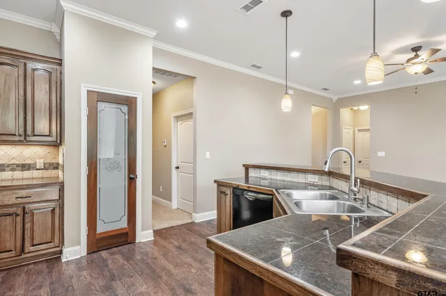 a kitchen with a sink a counter space and stainless steel appliances