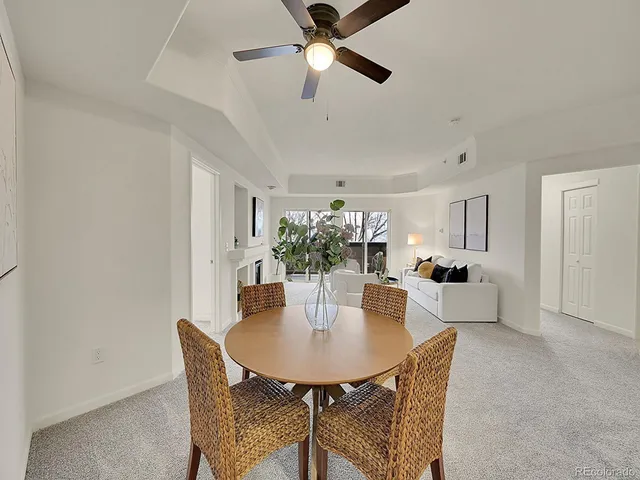a view of a dining room with furniture and a chandelier fan