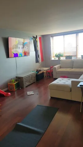 a living room with furniture gym equipment and a window