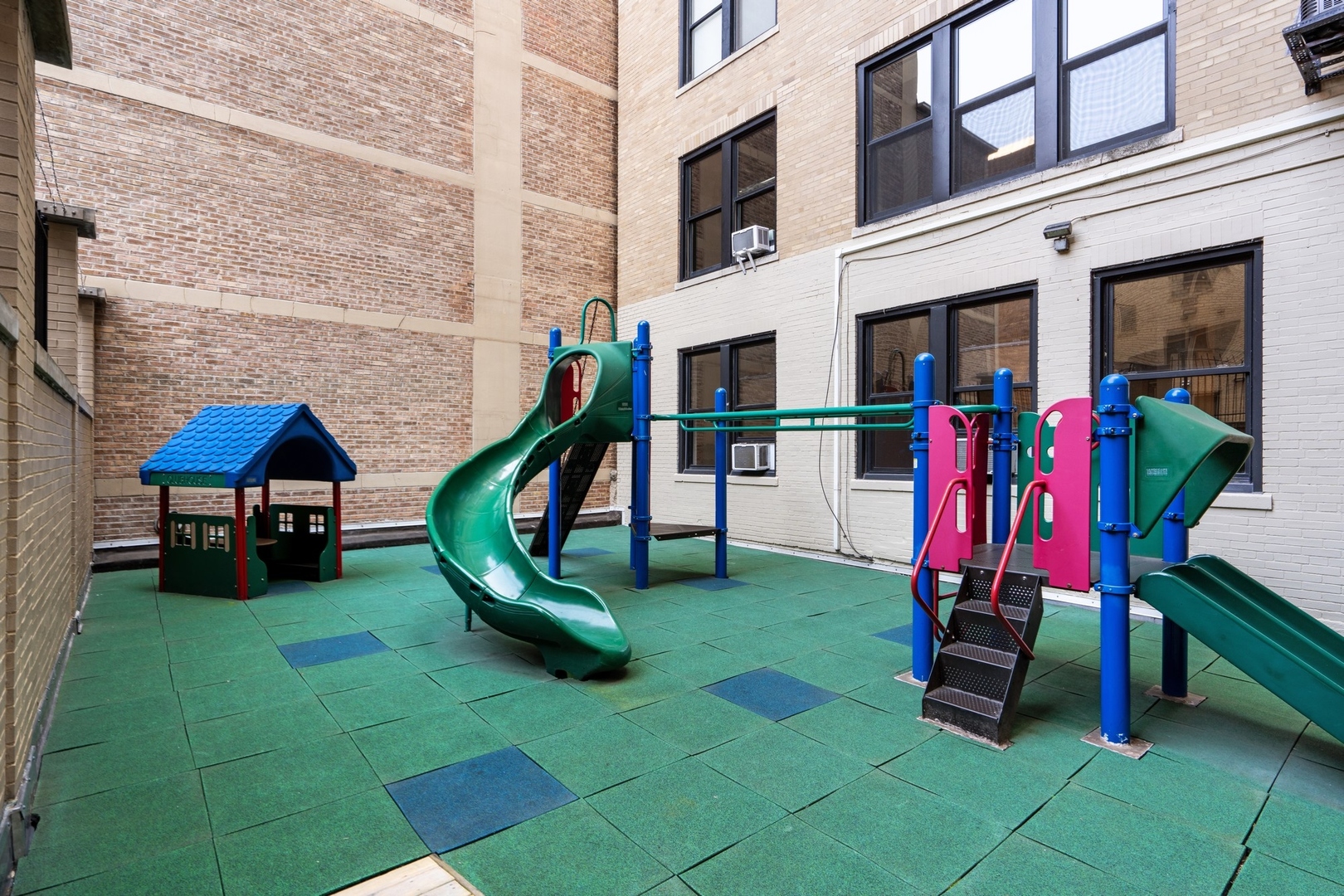 3100 North Sheridan Road, Unit 14B Chicago, IL 60657 - Photo 49 of 50 a view of a backyard with a slide and a bench