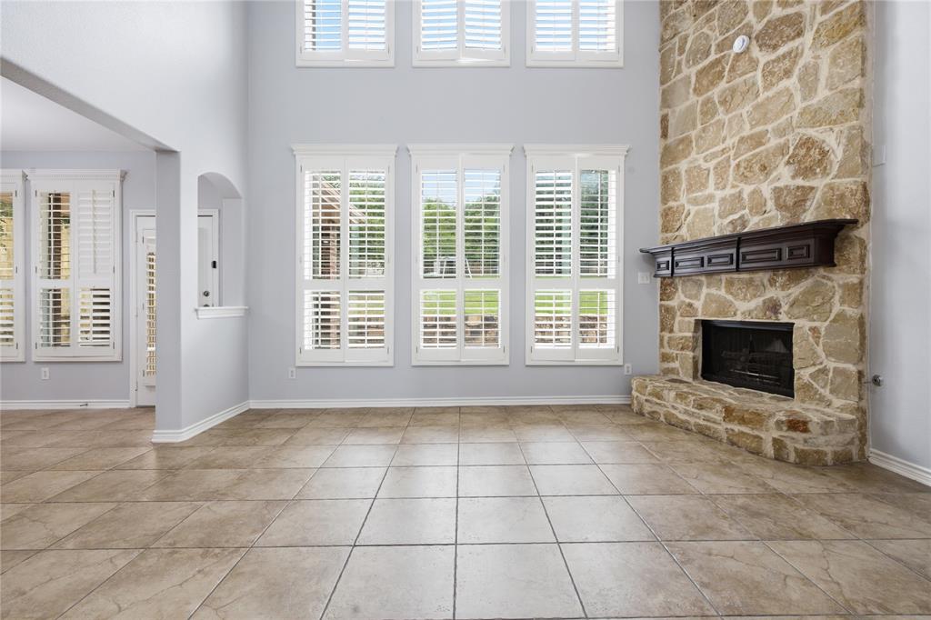 10001 Thurman Road Fort Worth, TX 76244 - Photo 11 of 40 Two-story stone fireplace with a dark wood mantelpiece