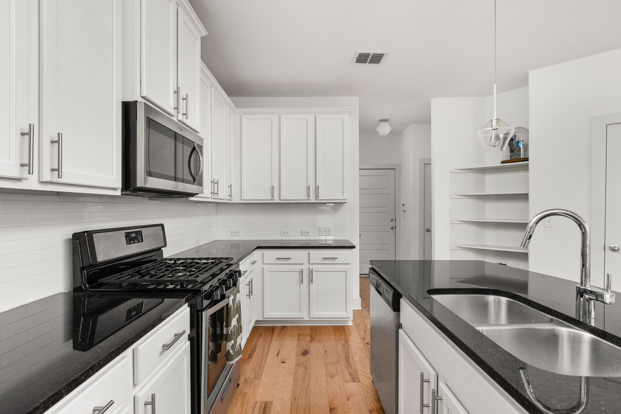 907 Totis Road Austin, TX 78748 - Photo 7 of 30 Kitchen featuring granite countertops, island, breakfast bar, gas range, stainless steel appliances, white cabinetry and recessed lighting