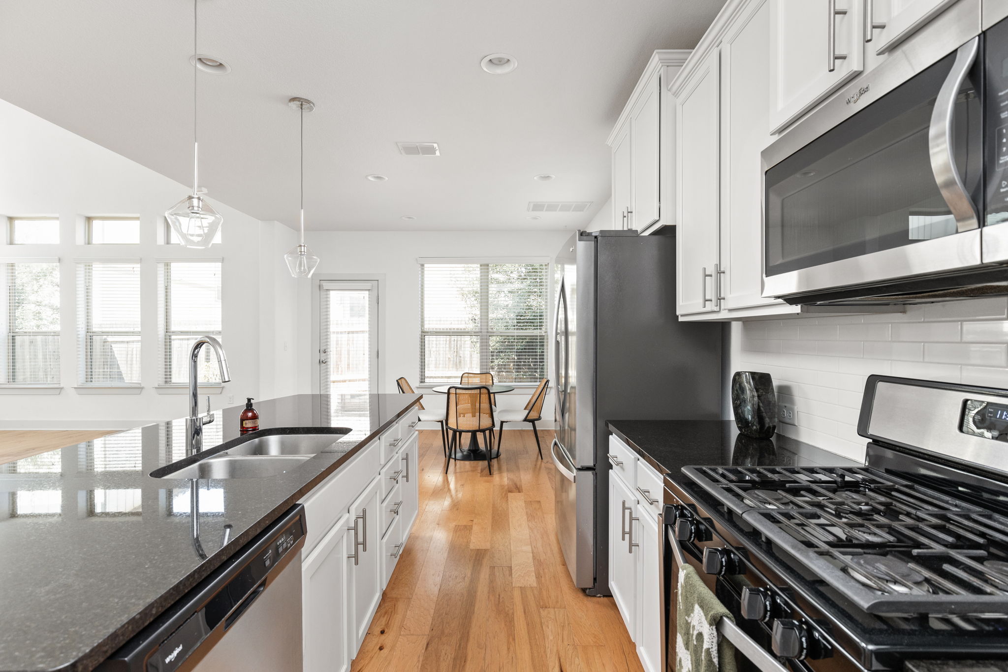 907 Totis Road Austin, TX 78748 - Photo 8 of 30 Kitchen featuring granite countertops, island, breakfast bar, gas range, stainless steel appliances, white cabinetry and recessed lighting