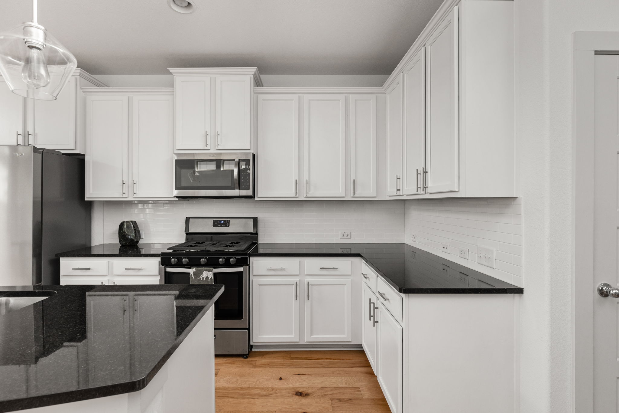 907 Totis Road Austin, TX 78748 - Photo 9 of 30 Kitchen featuring granite countertops, island, breakfast bar, gas range, stainless steel appliances, white cabinetry and recessed lighting