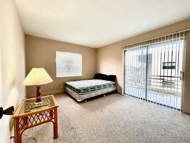 a bedroom with a bed and a lamp next to a window
