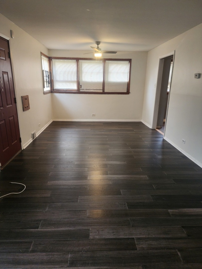948 West Vermont Street Chicago, IL 60643 - Photo 3 of 9 an empty room with wooden floor and windows