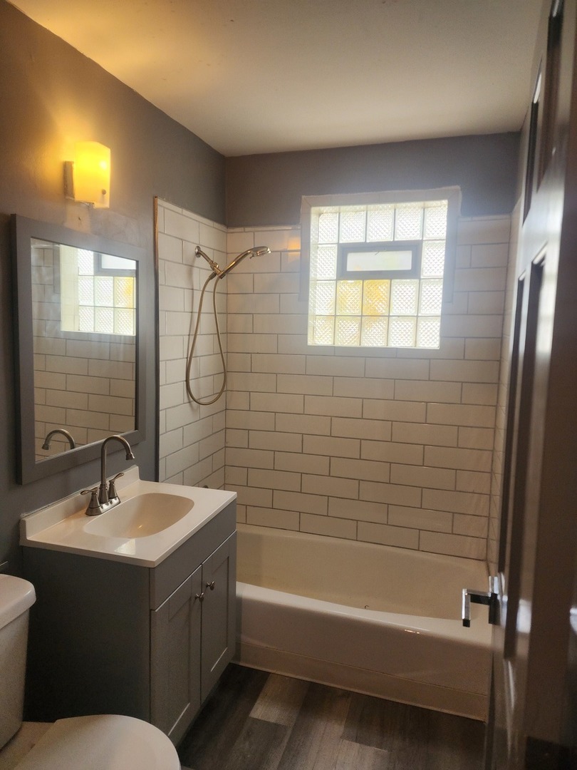 948 West Vermont Street Chicago, IL 60643 - Photo 4 of 9 a bathroom with a bathtub a sink a mirror a vanity and window