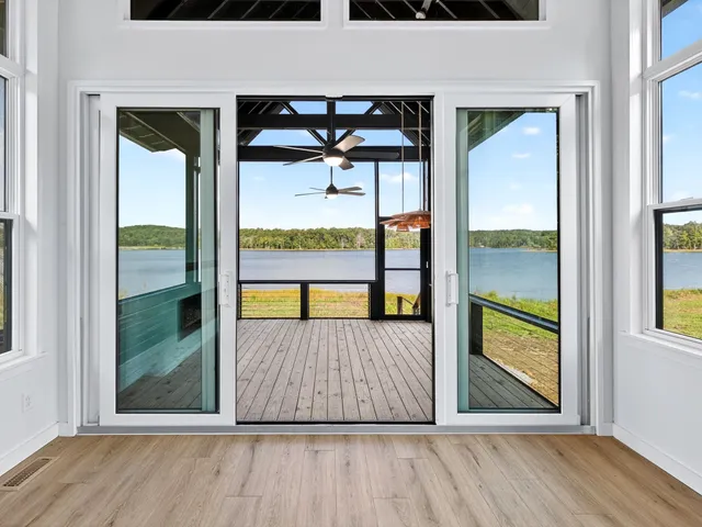 a view of an empty room with wooden floor and windows
