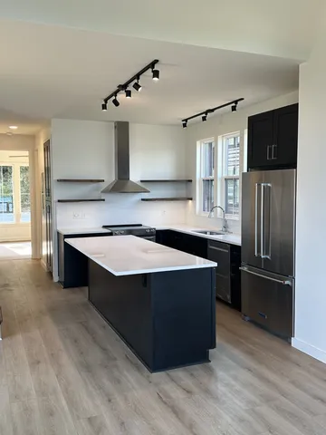 a view of an empty room with window and cabinet area
