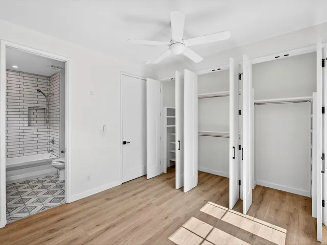 a view of an empty room with wooden floor and windows