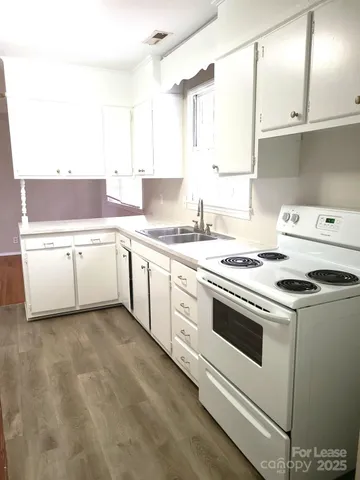 a kitchen with a stove sink and cabinets