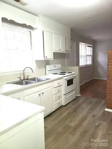 a kitchen with granite countertop white cabinets and white appliances