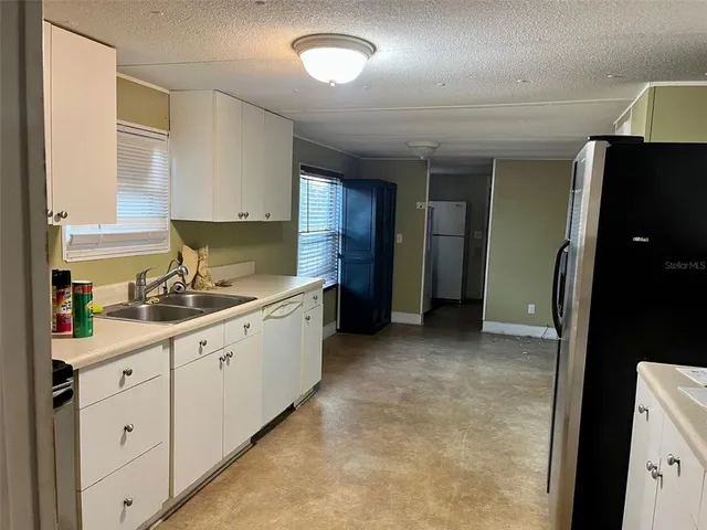 a kitchen with sink cabinets and refrigerator