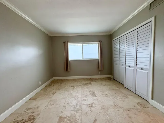 an empty room with closet and natural light