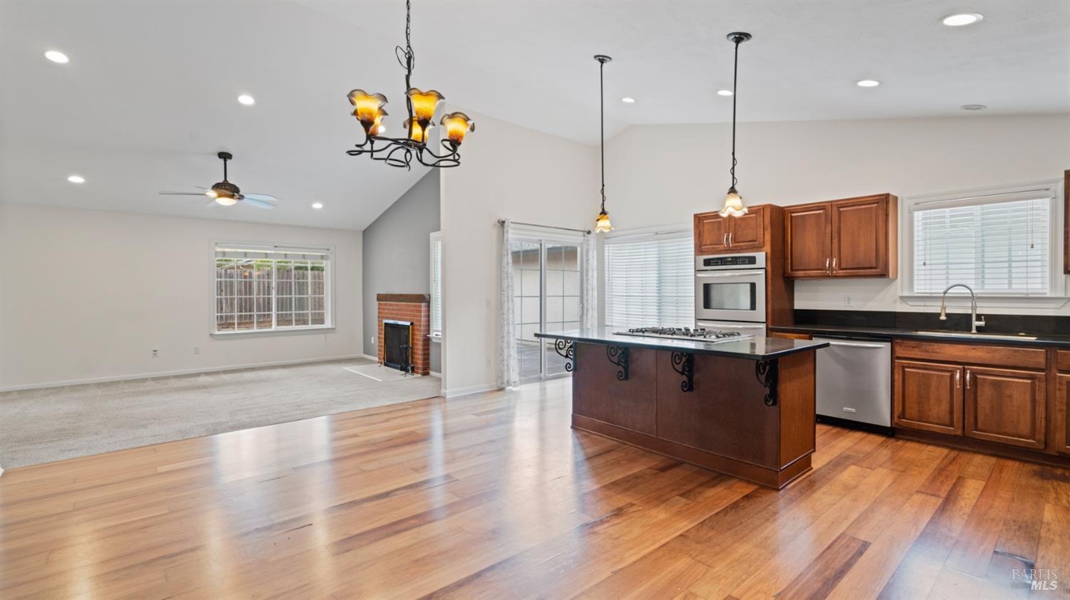 Great kitchen, family room and dining area in this cathedral ceiling space. SINGLE LEVEL. This angle shows the space for a dining area with a table below the chandelier. There is a window from the walkway, so there is both natual light and great overhead light. Great family and get-together space, with room to head outside!
