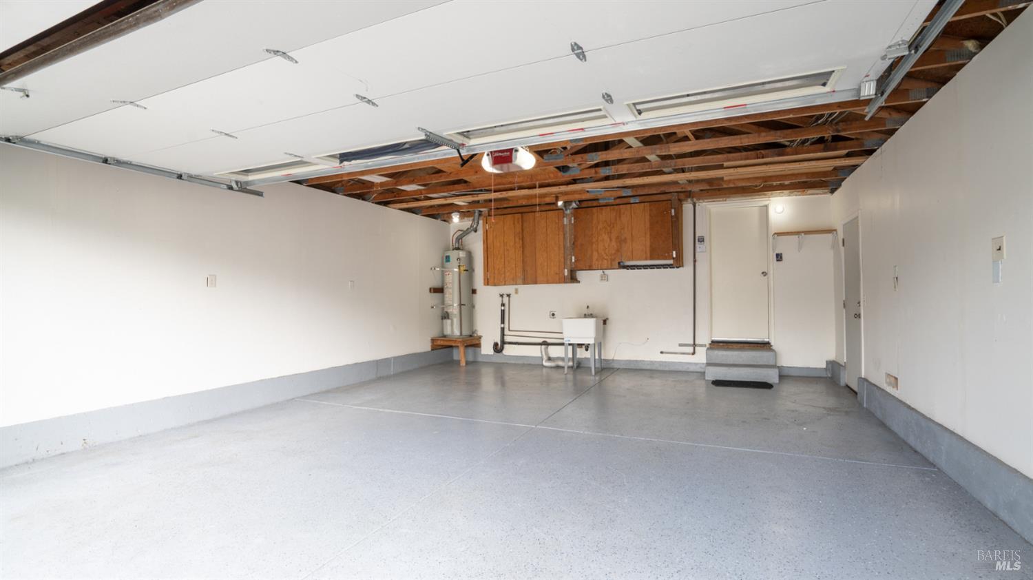6454 Amberwood Street Rohnert Park, CA 94928 - Photo 15 of 18 Another view towards garage showing laundry sink, hot water heater and laundry area.