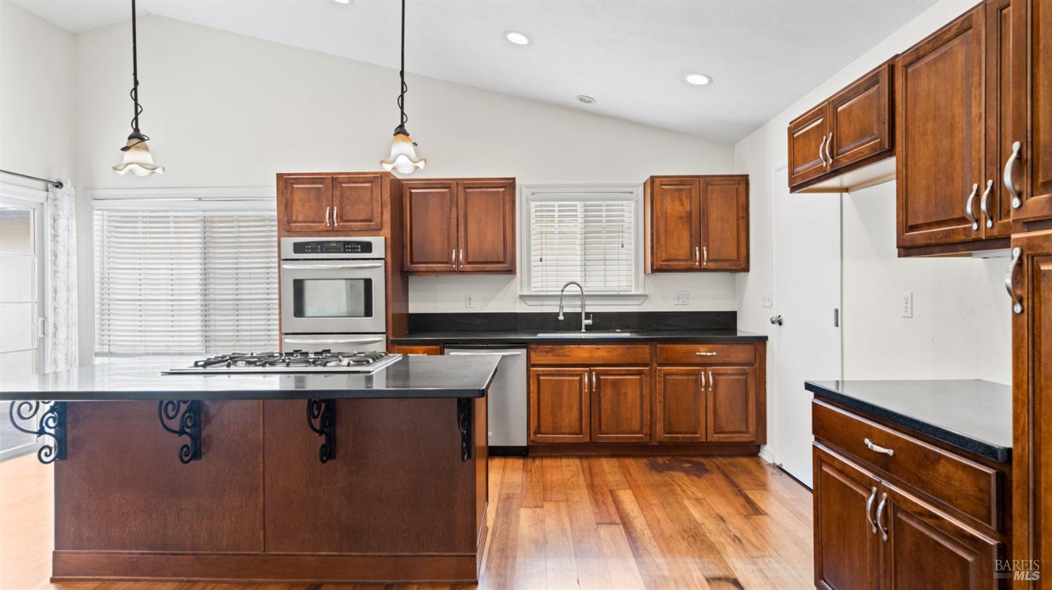 6454 Amberwood Street Rohnert Park, CA 94928 - Photo 2 of 18 This kitchen was remodeled by former residents about 8 years+. Kitchen island holds a gas stove with room for hi-back chairs. Lots of recessed lighting plus pendant and chandelier over dining area. Door to right leads to garage; door to left leads to outdoors.