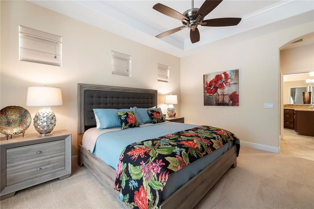 7608 Rio Bella Place Bradenton, FL 34201 - Photo 21 of 26 a bedroom with a bed and a chandelier