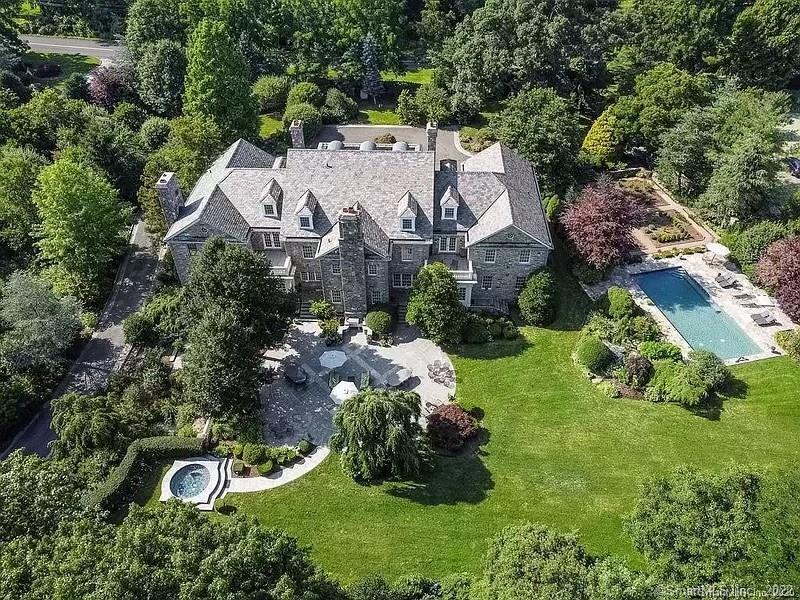 an aerial view of residential house with outdoor space and trees all around
