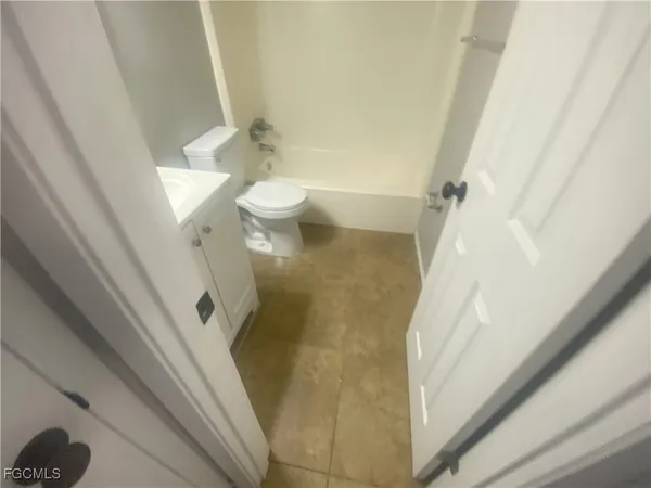 a bathroom with a granite countertop shower and a toilet