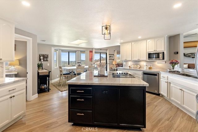 a kitchen with kitchen island granite countertop a sink and refrigerator