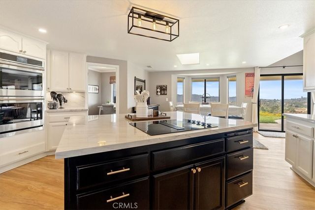 a kitchen with stainless steel appliances a stove a sink a microwave a refrigerator and cabinets