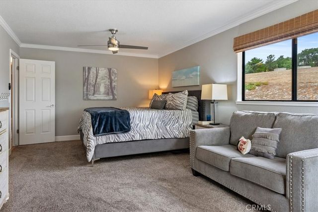 a view of a patio with table and chairs under an umbrella with a small garden