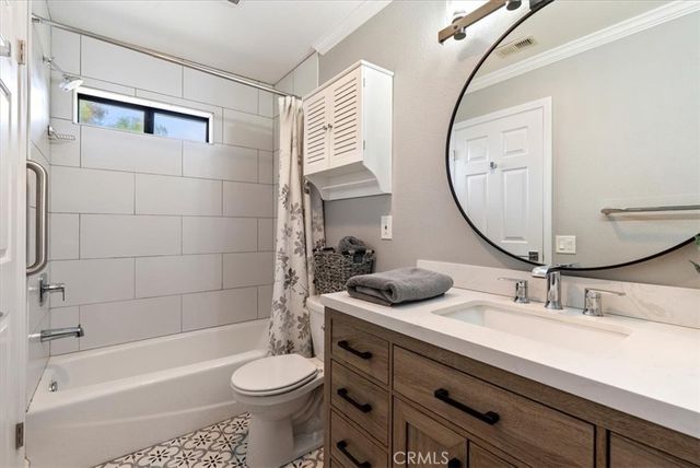 a bedroom with a large bed a flat tv screen and dresser