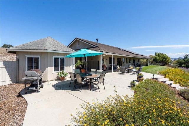 a view of a swimming pool and lounge chairs in back yard of the house