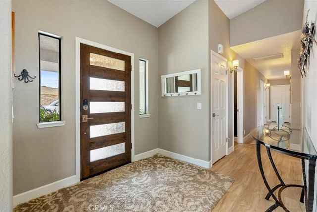 a living room with furniture a rug potted plant and a large window