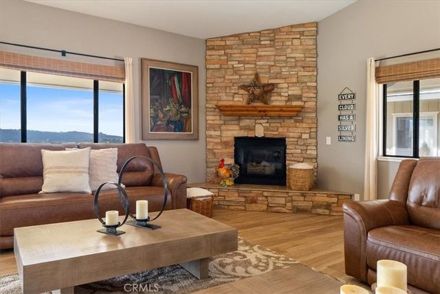 a living room with furniture kitchen view and a large window
