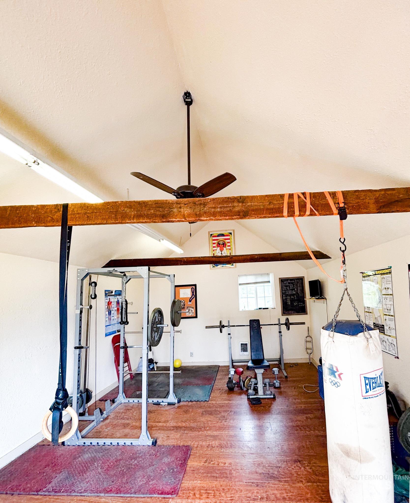 1995 Glenwood Road Kamiah, ID 83536 - Photo 35 of 38 Spacious room featuring vaulted ceilings with exposed wood beams, wood-finish flooring, and ample natural light from a double-pane window