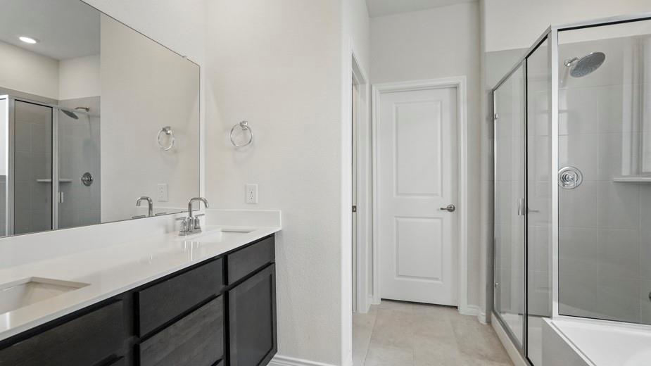 4162 Waldron Trail Forney, TX 75126 - Photo 17 of 29 Dual sink vanity with dark wood-finish cabinetry, white countertops, and chrome fixtures