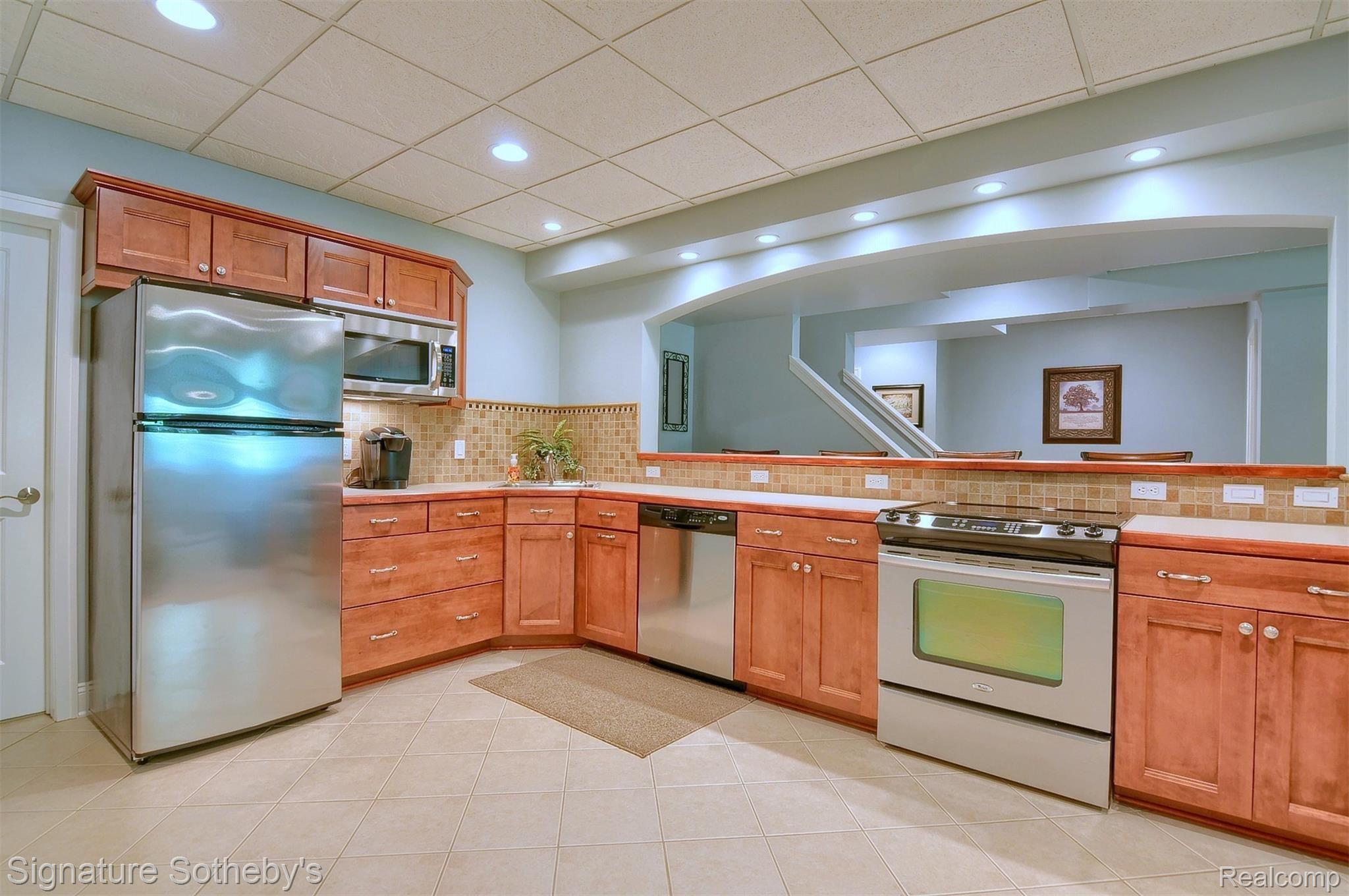 12293 Ivy Lane Fenton, MI 48430 - Photo 29 of 43 Lower Level Kitchen Cherry Cabinetry, recessed lighting, Stainless Appliances stay!