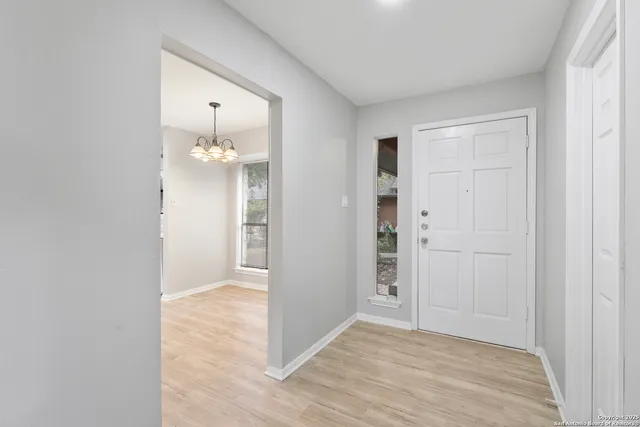 a view of a kitchen with a sink and dishwasher with wooden floor