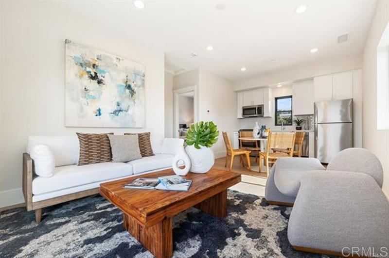 a living room with furniture a refrigerator and a dining table