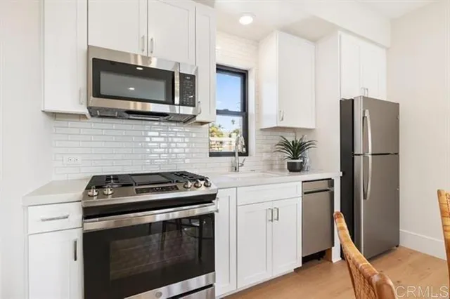 a kitchen with stainless steel appliances a stove microwave and refrigerator