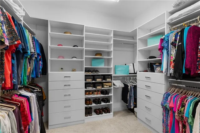 a view of walk in closet with clothes and shoes
