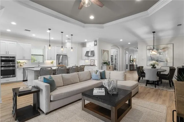 a living room with furniture kitchen and a chandelier